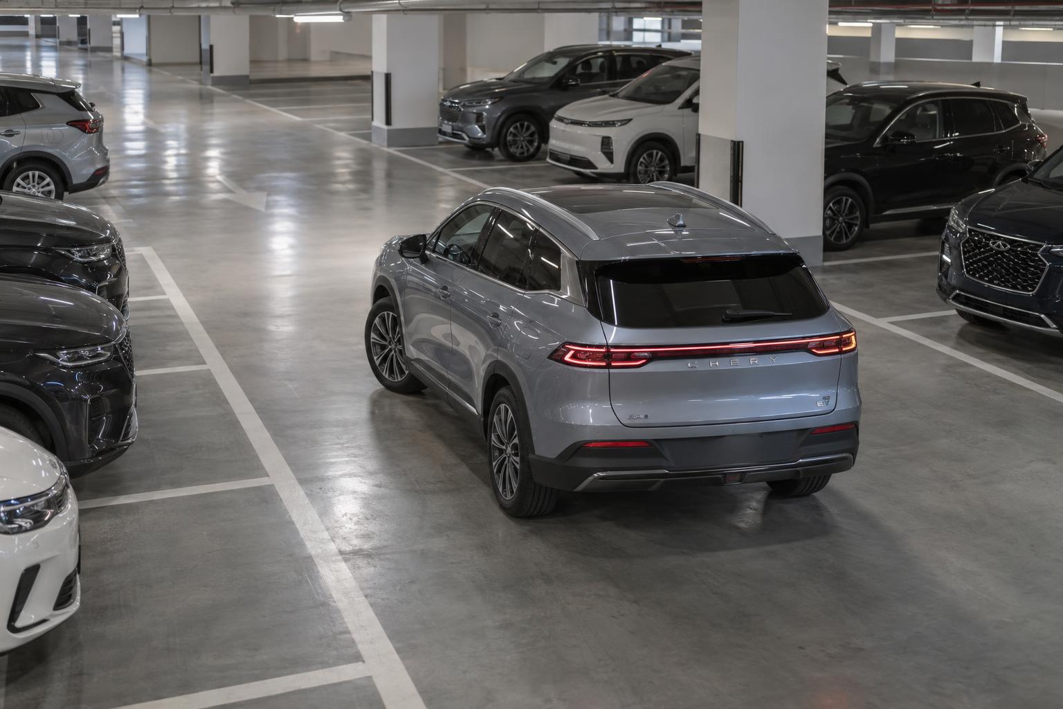 A Chery Group electric crossover carefully aligning into an empty bay in a UAE parking garage.