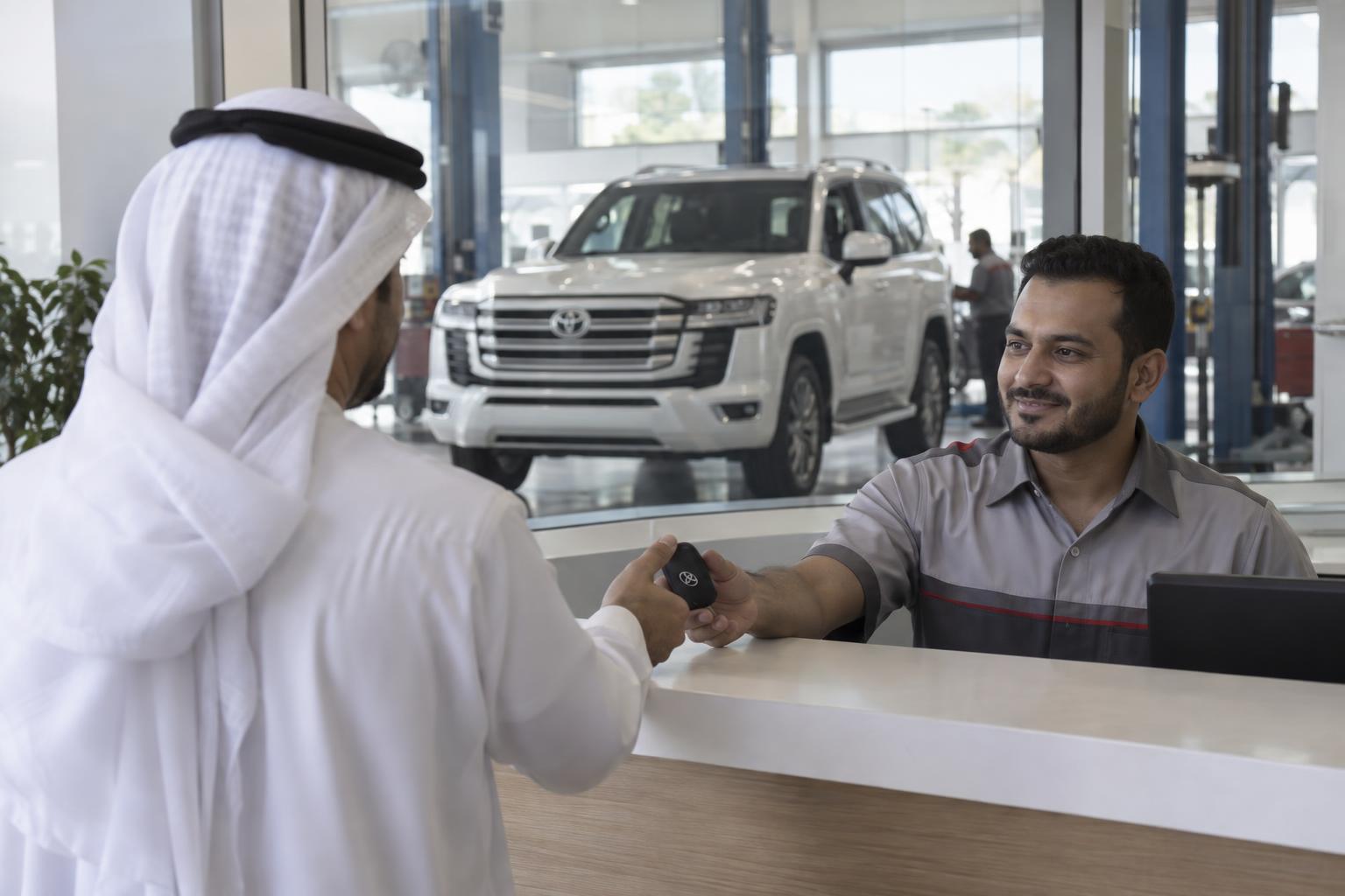 Land Cruiser owner handing keys to a service advisor at a UAE service centre.