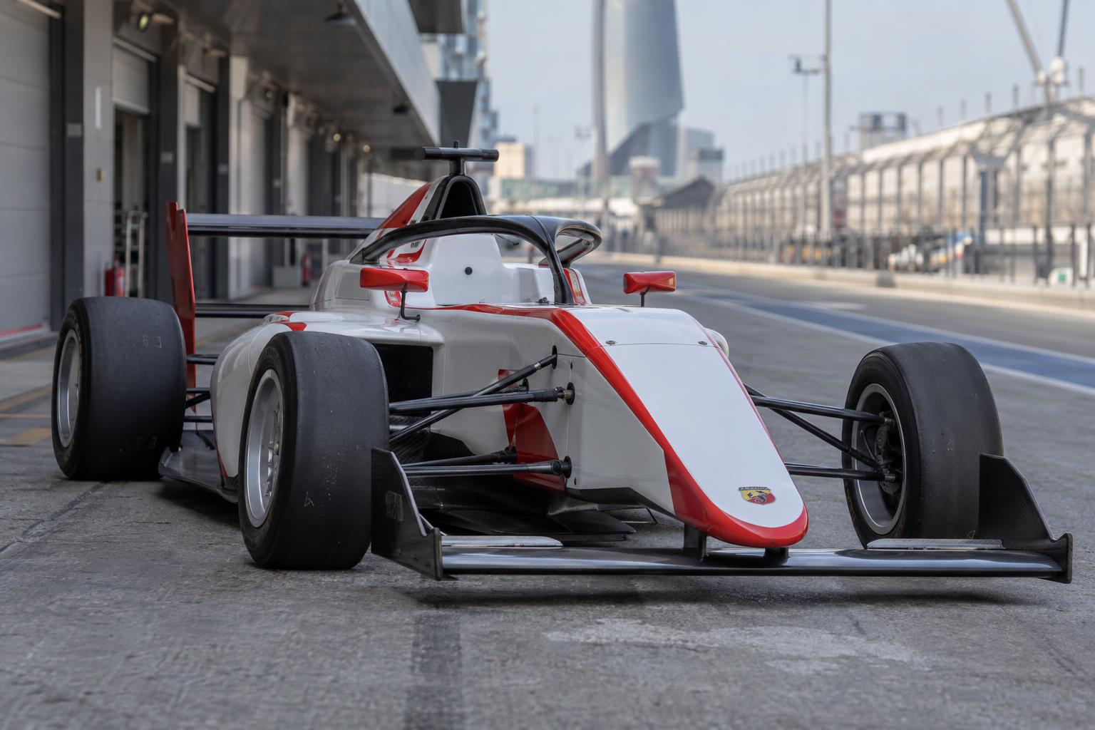 Close three-quarter view of a Tatuus T421 Abarth Formula 4 car in the pit lane.