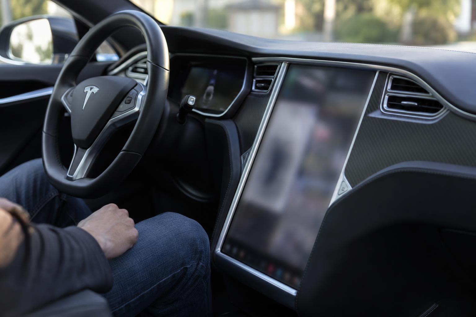 Tesla Model S central display and dashboard seen from the passenger side.