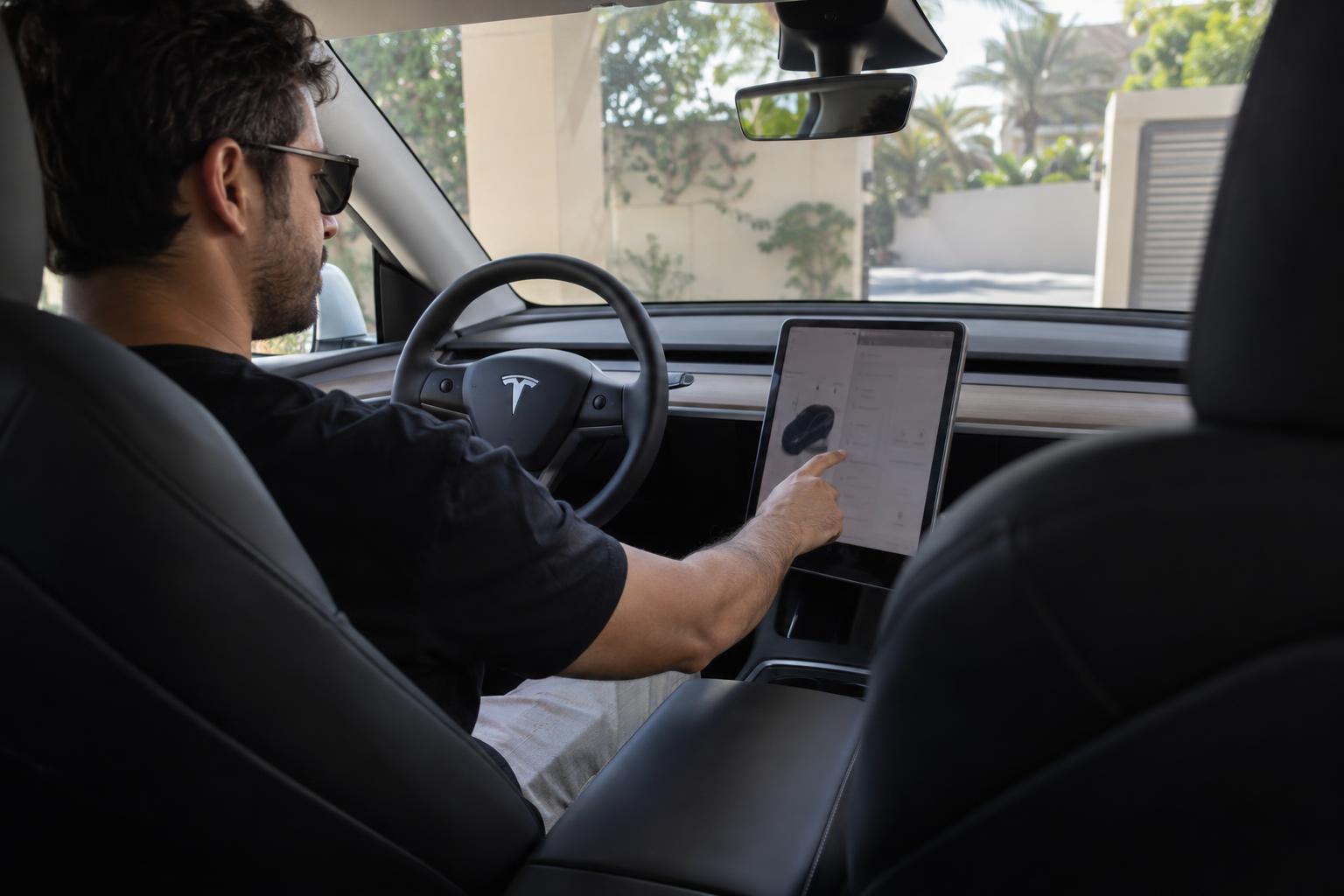 Tesla owner checking the central touchscreen for a software update while parked.