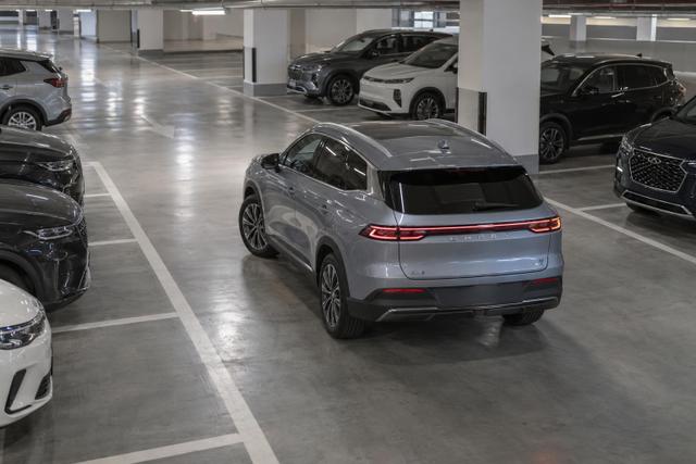A Chery Group electric crossover carefully aligning into an empty bay in a UAE parking garage.