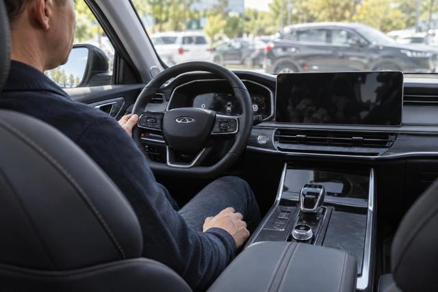 View across the cabin of a Chery SUV with a driver preparing to park.