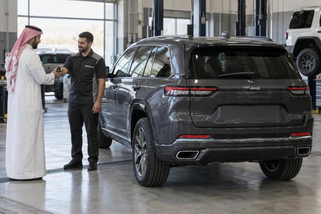 A Jeep owner receives their vehicle key after service at a dealership.