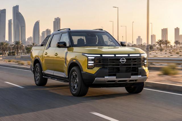 Nissan Frontier Pro pickup driving on a modern Gulf highway.