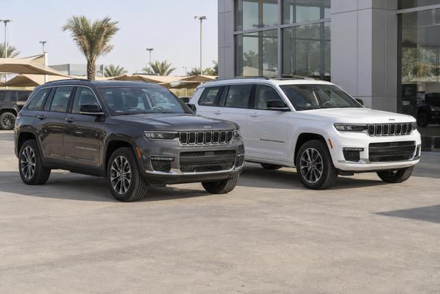 Jeep Grand Cherokee and longer Grand Cherokee L models parked together.