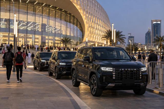 JETOUR SUVs wait outside a modern Qatar basketball arena at dusk.