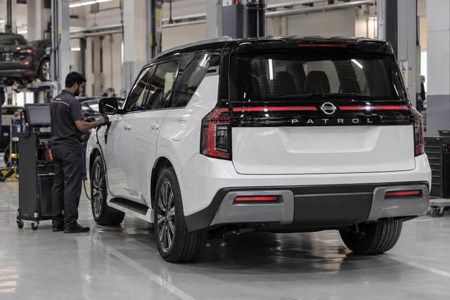 A Nissan Patrol Y63 parked in a service bay while a technician connects diagnostic equipment.