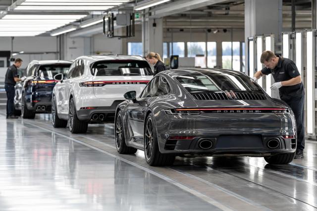 Porsche vehicles undergoing inspection in a modern production facility.
