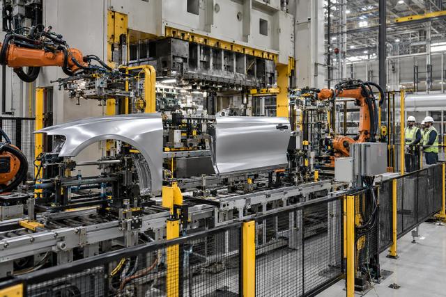 Automated stamping equipment forming vehicle body panels inside a modern car factory.