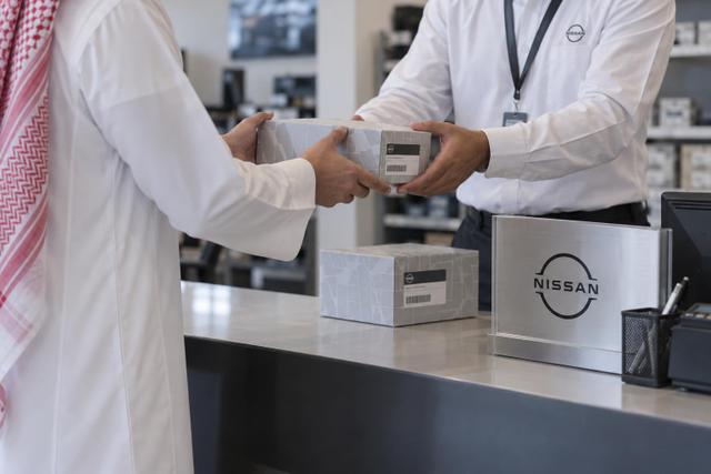 Driver receives sealed service parts from an adviser at a verified supplier counter.