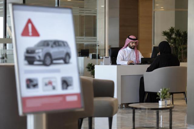 A neutral Saudi public-service office setting representing a vehicle safety recall announcement.